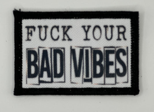 a black and white patch that says, fuck your bad vibes