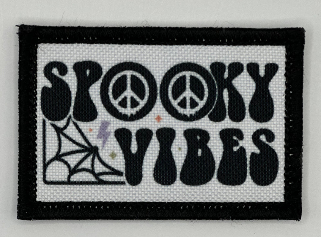 a black and white patch with the words spooky vibes