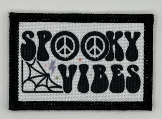 a black and white patch with the words spooky vibes