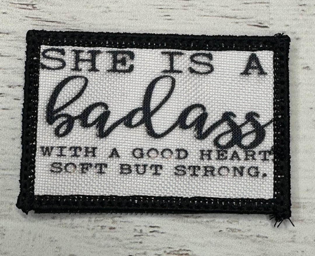 a black and white patch with the words she is a badass with a good