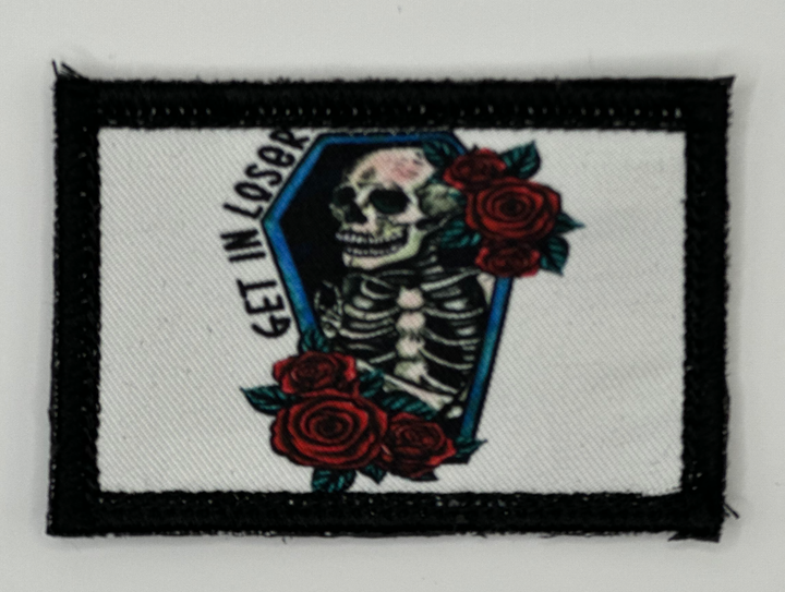 a patch with a skeleton and roses on it
