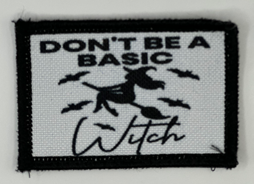 a black and white patch with a witch saying don't be a basic witch