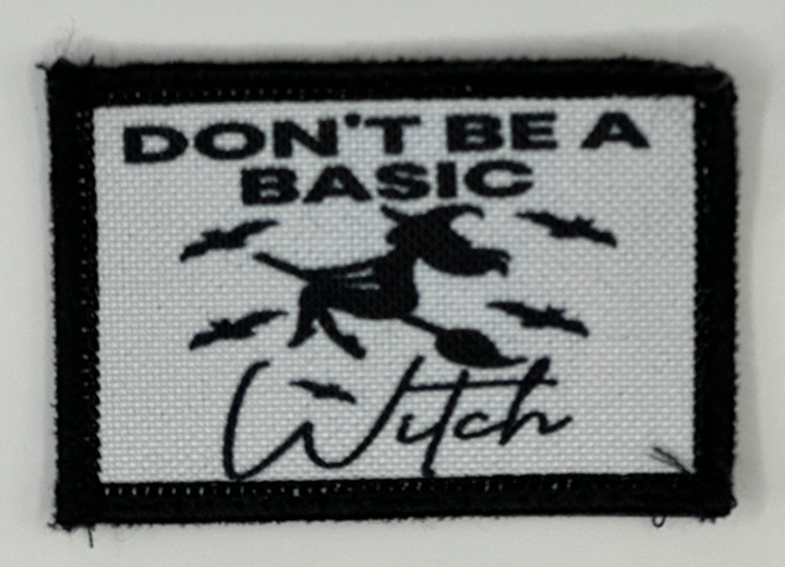 a black and white patch with a witch saying don't be a basic witch