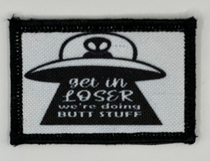 a black and white patch with a picture of an alien on it