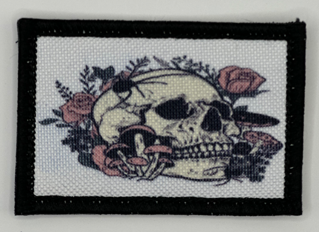 a cross stitch picture of a skull and flowers
