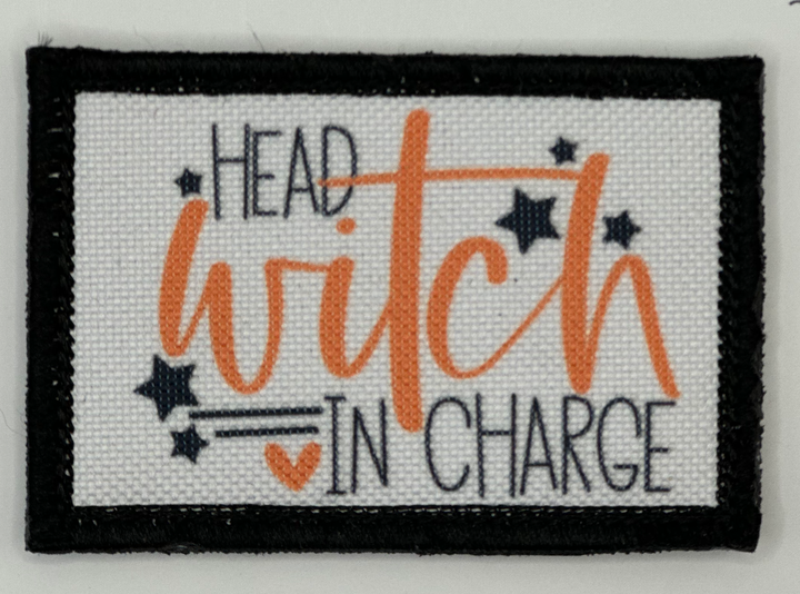 a black and orange patch with the words head witch in charge